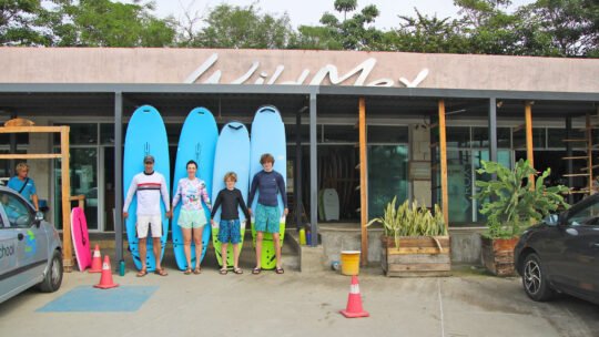 Family posing with surfboards in front of WildMex surf shop in Punta Mita