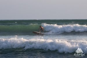 Hombre surfeando olas cristalinas en Punta Mita