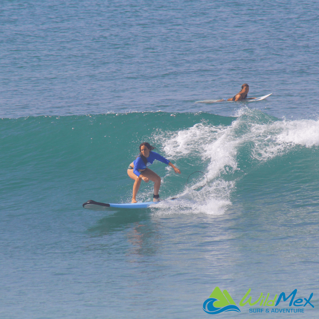 Girl taking surf lesson with sof top board in Punta Mita Nayarit Mexico