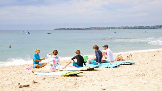 Surf instructor teaching family on land in Punta Mita