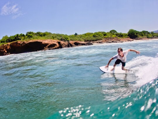 Surfer practicing maneuvers on a wave at La Lancha beach during WildMex coached session