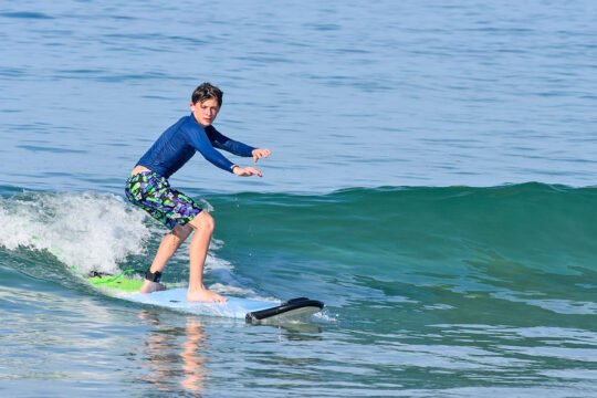 Surfer balancing on a wave at La Lancha beach