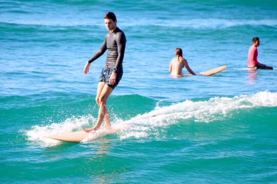 Focused surfer riding a wave at La Lancha beach
