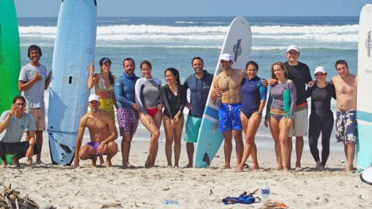 Adult surfers and WildMex instructors posing after a surf camp session in Punta Mita, Mexico