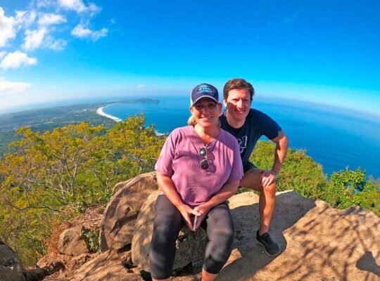 Couple smiling at Monkey Mountain summit during jungle hike