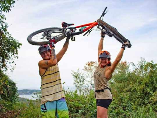Couple lifting mountain bike together during WildMex tour