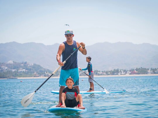 WildMex instructor assisting a child during SUP lesson in Sayulita